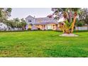 Sprawling front lawn leads to a well-maintained two-story home with a welcoming covered porch at 518 Riverside Dr, Tarpon Springs, FL 34689