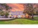 Elegant home featuring manicured lawn, neutral palette, dormer windows, and covered porch at 518 Riverside Dr, Tarpon Springs, FL 34689
