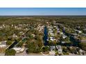 Aerial view showcases the neighborhood's unique canal system surrounded by lush trees, and nearby waterways at 7176 Westwind St, Weeki Wachee, FL 34607