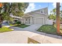 Two-story home with gray siding, a two-car garage, and a front yard at 1815 E 22Nd Ave, Tampa, FL 33605