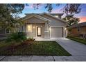Two-story house with gray siding, landscaping, and a two-car garage at dusk at 1815 E 22Nd Ave, Tampa, FL 33605