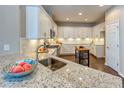 Modern kitchen with white cabinets, granite countertops, and a large island at 2004 Sidney St, Clearwater, FL 33763