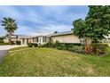Tan house with lush landscaping and a screened porch at 2739 Sherbrooke Ln # B, Palm Harbor, FL 34684