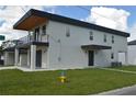 Modern two-story house with a gray facade, dark garage door, and small balcony at 3915 W Robson St, Tampa, FL 33614