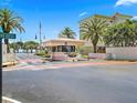 Gated entrance to a waterfront community, with palm trees and a guardhouse at 7600 Sun Island S Dr # 107, South Pasadena, FL 33707