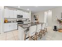 Modern kitchen with white cabinets, granite countertops, and an island with seating at 8968 Parsons Hill Blvd, Wesley Chapel, FL 33545