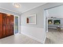 Inviting foyer with wood-look tile, a decorative mirror, and access to the living room at 2132 Academy Dr, Clearwater, FL 33764