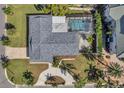 An aerial view of the property showcasing the home's layout, screened pool, landscaping, and roof at 910 Oakwood Dr, Largo, FL 33770