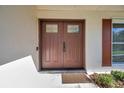 A close-up view of the inviting front door with glass inserts and sidelight, complemented by a charming shuttered window at 910 Oakwood Dr, Largo, FL 33770