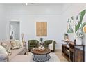 Living room features neutral colored couch and armchairs, coffee table and art at 3811 N Arlington Ave, Tampa, FL 33603