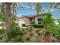 Tan house with white garage door and lush landscaping at 7820 Harbor Bridge, New Port Richey, FL 34654