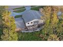 Aerial view shows a house with a large deck and surrounding trees at 223 S Riverhills Dr, Temple Terrace, FL 33617