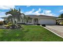 Single story house with palm trees and a well manicured lawn at 26159 Constantine Rd, Punta Gorda, FL 33983