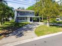 Two-story house with gray siding and a covered carport at 30 New York Ave, Dunedin, FL 34698