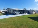Single-wide mobile home with carport and covered patio at 164 Colonial Ct # 19, Palm Harbor, FL 34684