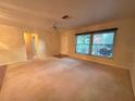 Bright living room featuring a large window and ceiling fan at 1670 Ne Rosery Rd, Largo, FL 33771