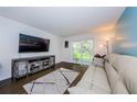Living room with large TV and sliding glass doors to patio at 211 S Mcmullen Booth Rd # 189, Clearwater, FL 33759