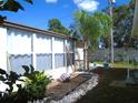 Landscaped side yard with tropical plants and rock border at 34029 Azalea N Dr, Pinellas Park, FL 33781