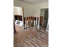Damaged kitchen with exposed framing and hardwood floors at 319 80Th Ne Ave, St Petersburg, FL 33702