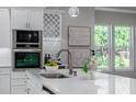 Modern kitchen with white cabinets, quartz countertops, and a stylish sink at 3845 Seena Manor Ct, Tampa, FL 33618