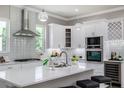 Spacious kitchen featuring white cabinets, stainless steel appliances, and a large island at 3845 Seena Manor Ct, Tampa, FL 33618