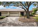 Two-car garage, front yard landscaping, and driveway at 1207 Lenham Ct, Sun City Center, FL 33573