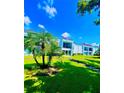 Landscaped grounds showcasing a condo building with palm trees and lush grass at 2060 Marilyn St # 239, Clearwater, FL 33765