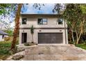 Modern two-story house with a large garage and landscaped yard at 21048 Peachland Blvd, Port Charlotte, FL 33954