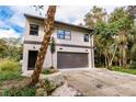Modern two-story house with a large garage and landscaped yard at 21048 Peachland Blvd, Port Charlotte, FL 33954