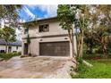 Modern two-story house with a large garage and landscaped yard at 21048 Peachland Blvd, Port Charlotte, FL 33954