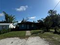 Front view of a teal single story house with yard at 847 Hand Ave, Sarasota, FL 34232