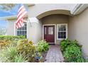 Inviting front entry with a brick walkway, lush landscaping and a red door at 1433 Emerald Hill Way, Valrico, FL 33594