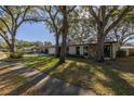 Home's exterior with driveway and large oak trees at 2227 Willowbrook Dr, Clearwater, FL 33764