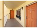 Apartment building hallway with an orange door and exit at 9000 Commodore Dr # 401, Seminole, FL 33776