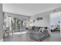 Spacious living room with gray sectional sofa and access to a balcony at 9000 Commodore Dr # 401, Seminole, FL 33776