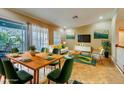 Bright living room boasts contemporary decor, a large dining table, and seamless access to an outdoor patio at 94 The Cove Way, Indian Rocks Beach, FL 33785