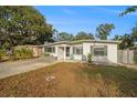 House exterior featuring a front yard, driveway and teal chair at 15133 Harding Ave, Clearwater, FL 33760