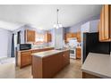 Kitchen with island, wood cabinets, and stainless steel appliances at 2102 Deltona Blvd, Spring Hill, FL 34606