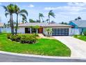 Charming single-story home with a modern garage door, a well-manicured lawn, and a brick driveway at 11683 Grove St, Seminole, FL 33772