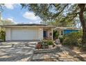 Ranch-style home with a large attached garage and colorful landscaping at 222 Riviere Rd, Palm Harbor, FL 34683