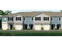 Three-unit townhome building, light blue exterior, white garage doors, and landscaping at 2472 Mellow Ln, Clearwater, FL 33765
