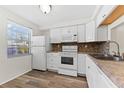 Efficient kitchen with white cabinets, tile backsplash and vinyl flooring at 4220 Sheldon Pl # 4220, New Port Richey, FL 34652