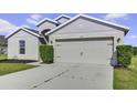 Two-car garage and neutral color exterior with landscaping at 6731 Wirevine Dr, Brooksville, FL 34602