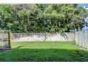 Exterior yard with mature trees and a tall wooden fence at 10100 Sailwinds N Blvd # 106, Largo, FL 33773