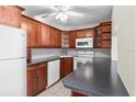 Kitchen with wood cabinets, dark countertops, and appliances at 1127 Pine Ridge W Cir # A2, Tarpon Springs, FL 34688