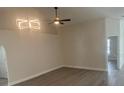 Spacious living room with a ceiling fan, modern light fixture, and neutral decor at 4611 Horseshoe Pick Ln, Valrico, FL 33594