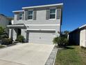 Two-story house with gray siding, gray shutters, landscaping, and a two-car garage at 16910 Trite Bend St, Wimauma, FL 33598