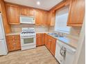 Bright kitchen with light wood cabinets, white appliances, and tile floors at 6020 Shore S Blvd # 508, Gulfport, FL 33707