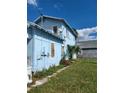 Side view of light blue house, showing yard and satellite dish at 1905 And 1907 N Armenia Ave, Tampa, FL 33607