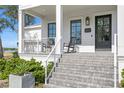 Charming front porch featuring rocking chairs and well-maintained landscaping, creating an inviting entrance at 5811 Mariner St, Tampa, FL 33609